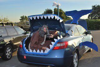 a man sitting in the back of a car with a shark's mouth open