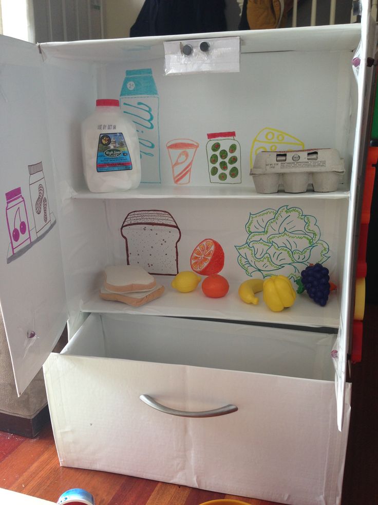 an open refrigerator door with food on the shelves and other items in front of it