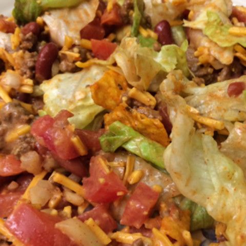 a white plate topped with taco salad and tortilla chips