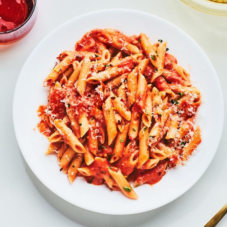 a white plate topped with pasta covered in sauce