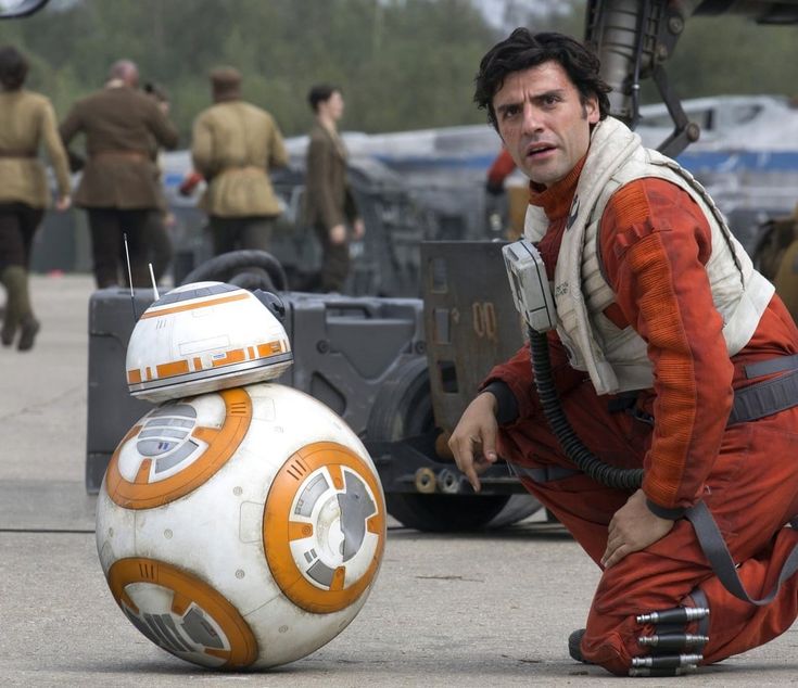 a man kneeling down next to a star wars bbg ball