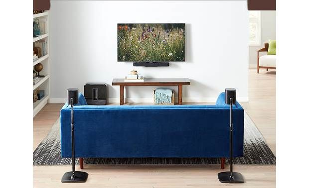 a living room with a blue couch and speakers