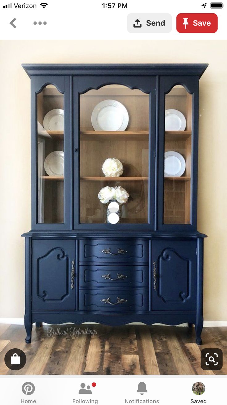 a blue china cabinet with glass doors and drawers