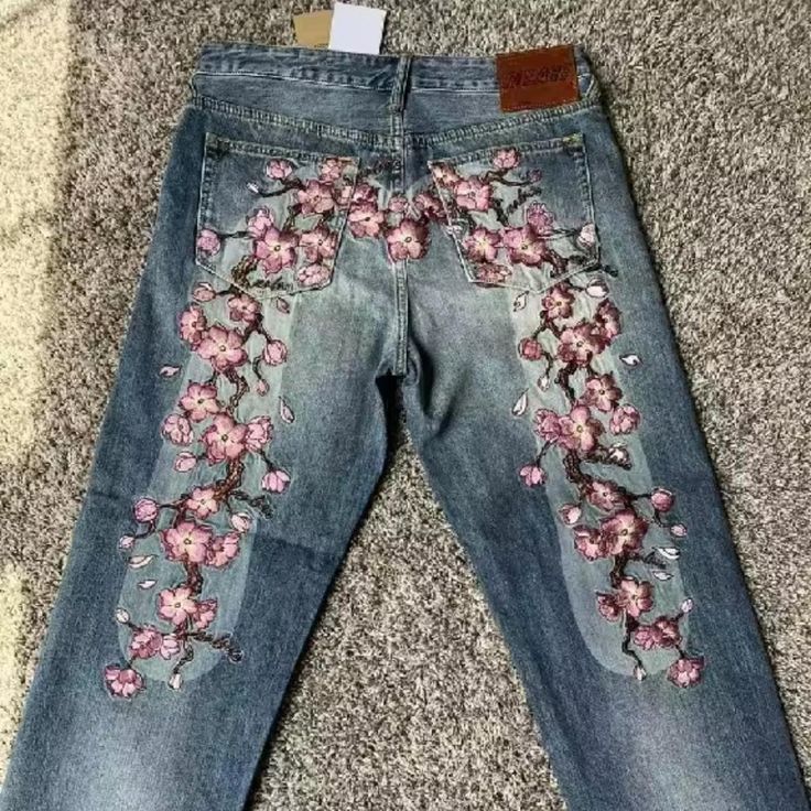 a pair of jeans with pink flowers on them