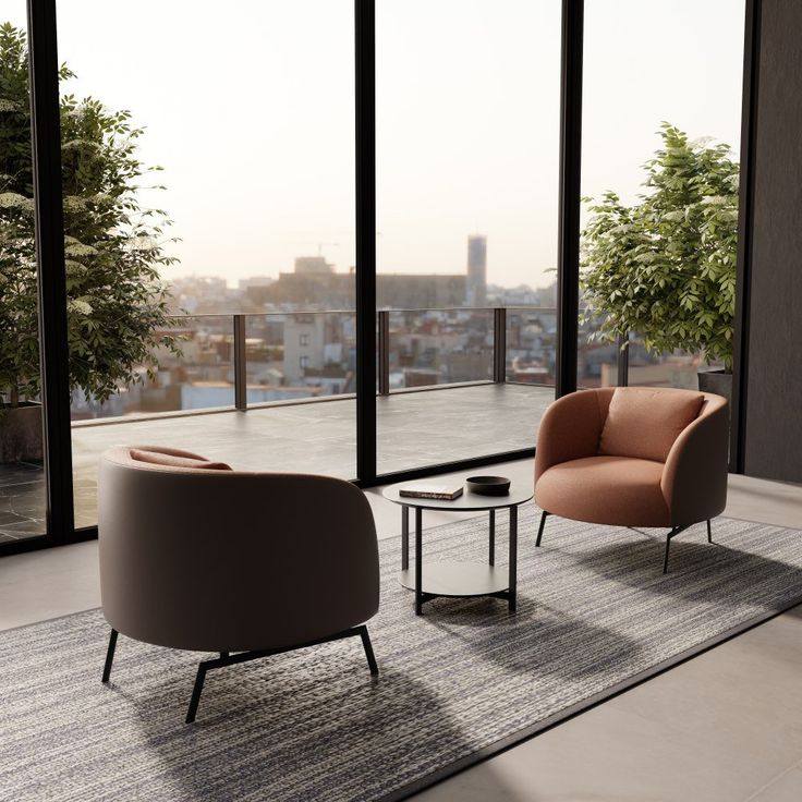 a living room with two chairs and a table in front of large windows overlooking the city