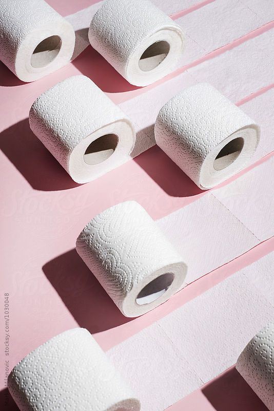 several rolls of toilet paper on a pink surface