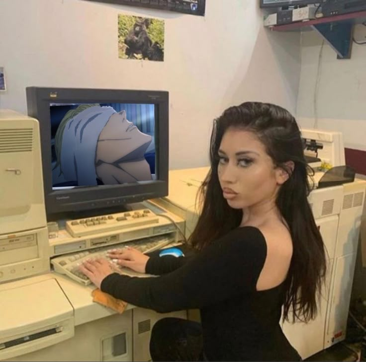 a woman sitting in front of a computer with a monitor on it's side