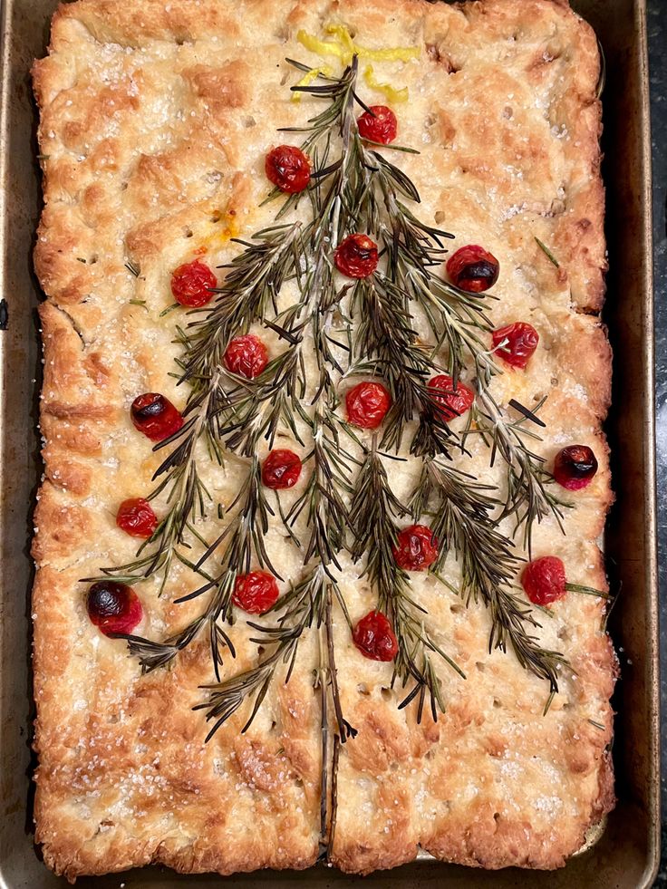 a christmas tree made out of bread in a baking pan with cranberries and rosemary