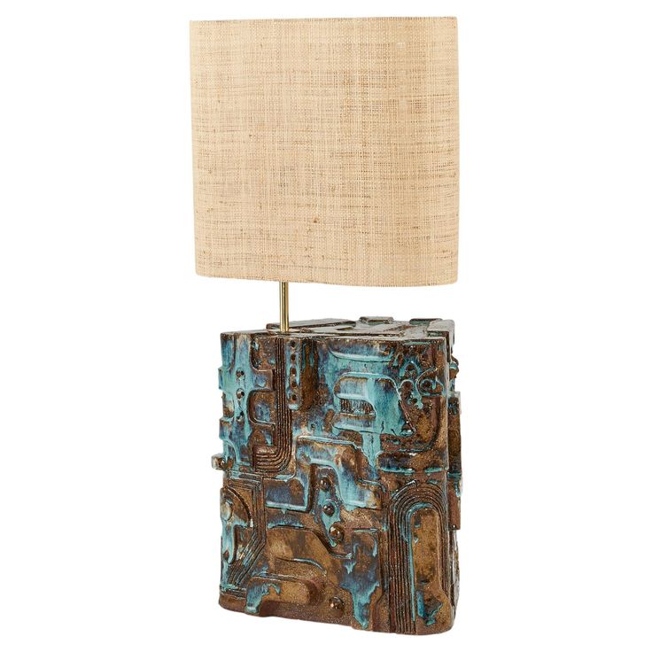 a lamp that is on top of a wooden block with a fabric shade over it