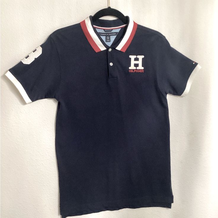 Tommy Hilfiger, Boys (Juniors), Logo Polo Shirt, Size: 20, Color: Navy Blue, Condition: Brand New, Unused, Pullover, Collar, Short Sleeves Material: Cotton, Polyester, Machine Washable, Logo On Chest Of Polo Shirt Navy Cotton Top For College, Navy Cotton Tops For College, Blue Collared Tops For College, Sporty Navy Cotton Polo Shirt, Preppy Navy Cotton Top, Preppy Black Cotton Top, Blue Polo Collar Top For Streetwear, Preppy Blue Cotton Polo Shirt, Tommy Hilfiger Cotton College Tops