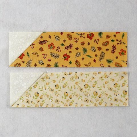 two pieces of fabric with flowers and leaves on them, one is yellow and the other is white