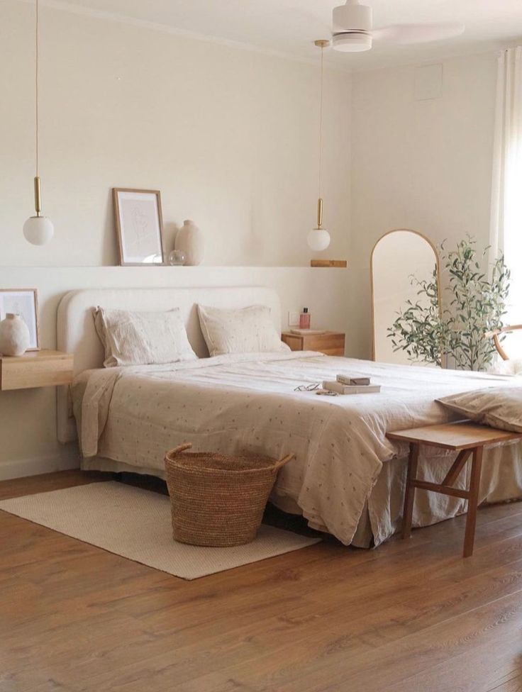 a bedroom with white walls and wooden floors