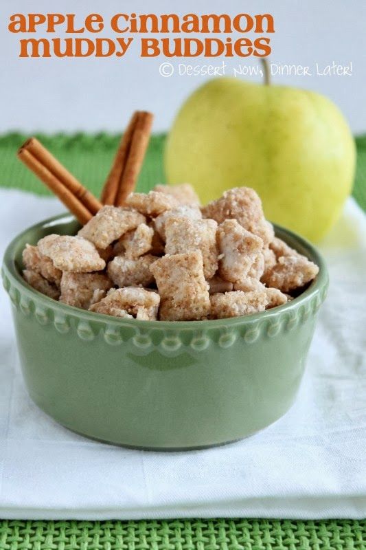 a green bowl filled with puppy chow next to an apple and cinnamon stick on a table