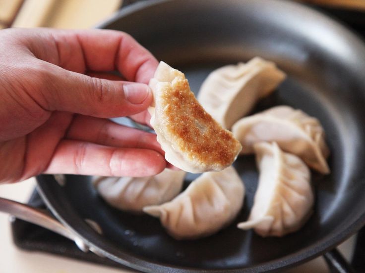 a person is holding some food in a frying pan