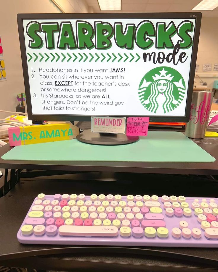 a pink keyboard sitting on top of a desk next to a sign that says starbucks made