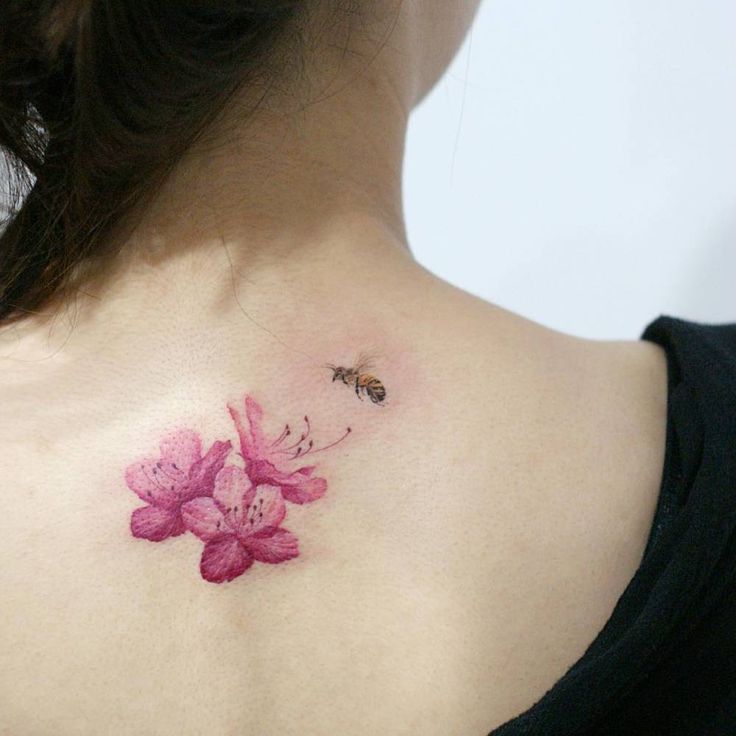 a woman with a pink flower tattoo on her back