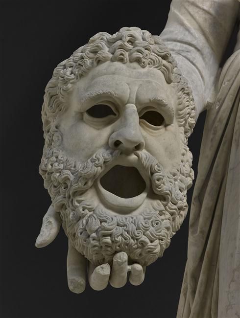 a close up of a statue of a man's face with his hands in the air