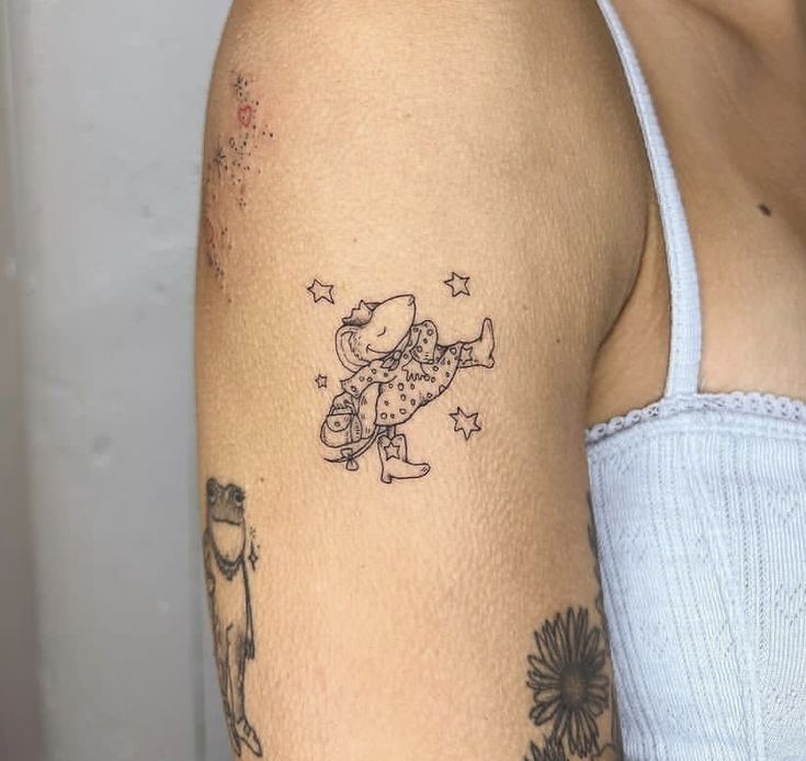 a woman's arm with a tattoo on it that has an image of a cartoon character