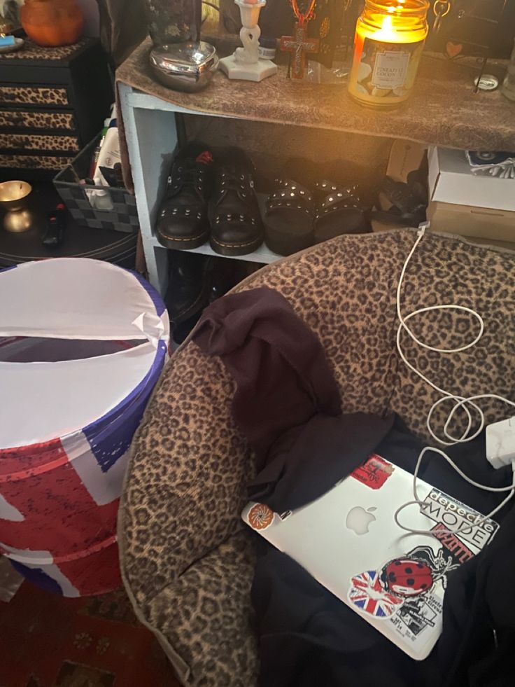 an open laptop computer sitting on top of a leopard print chair next to a table