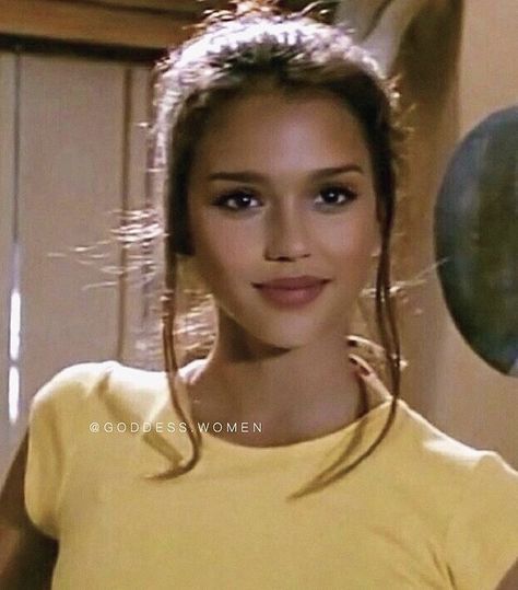 a young woman in a yellow shirt posing for the camera