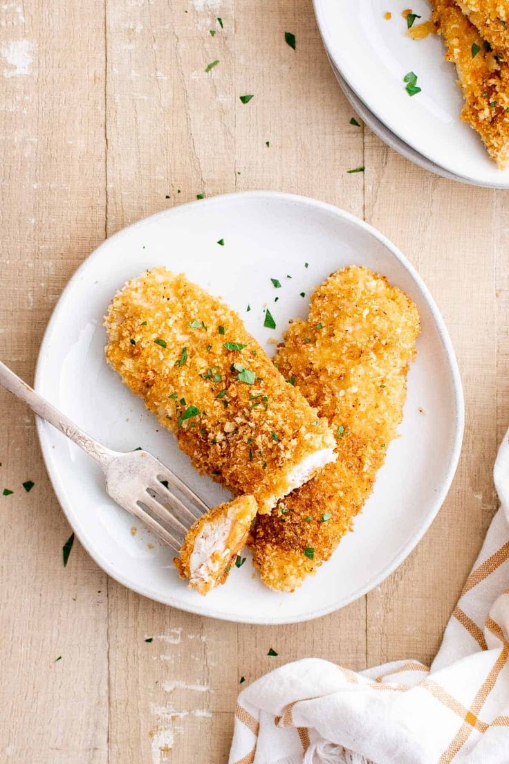 two plates that have some food on top of them and one has a fork in it