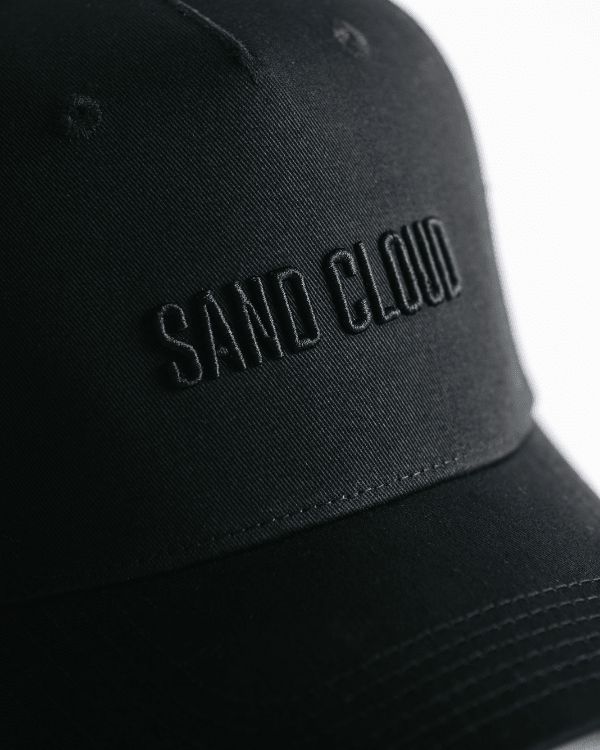 Introducing the Sand Cloud Trucker, a must-have for your sunny adventures. Made from 100% Cotton, featuring a 3-D embroidered logo in black, a recycled poly mesh, and a snapback closure. Unisex, with three inch visor. Approx size: 58 CM Color: Black Trucker Hat with 3D Sand Cloud Embroidery in Black 100% Cotton Made in China Care Details: Machine Wash Cold Delicate Cycle Do Not Bleach Hang Air Dry Do Not Iron Do Not Dry Clean Black Visor Hat With Logo Print, Black Baseball Cap With Logo Print, Functional Black Trucker Hat With Curved Brim, Functional Black Trucker Hat With Curved Bill, Sporty Outdoor Baseball Cap With Logo Patch, Adjustable Logo Baseball Cap For Outdoor, Sporty Trucker Cap With Embroidered Logo, Functional Summer Snapback Cap, Black Logo Print Baseball Cap For Streetwear