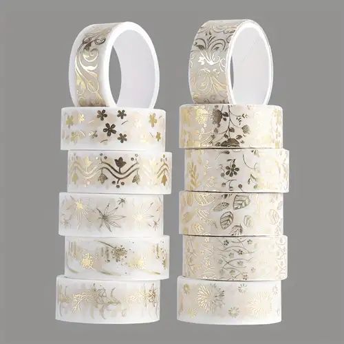 several rolls of white and gold washi tape with floral designs on the sides, against a gray background