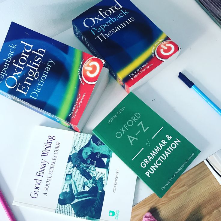 three books and a pencil on a table