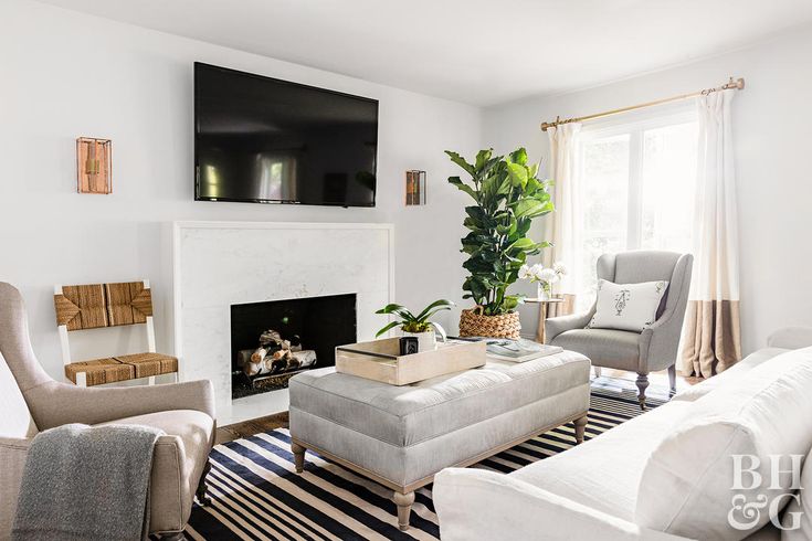 a living room filled with furniture and a flat screen tv mounted on the wall above a fireplace