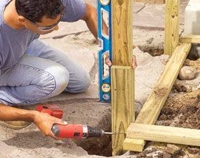 a man using a drill to fix a hole in the ground