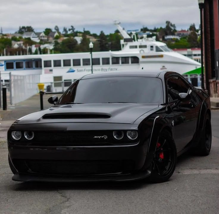 a black car parked in front of a boat