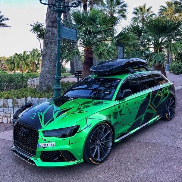 a green sports car parked in front of palm trees