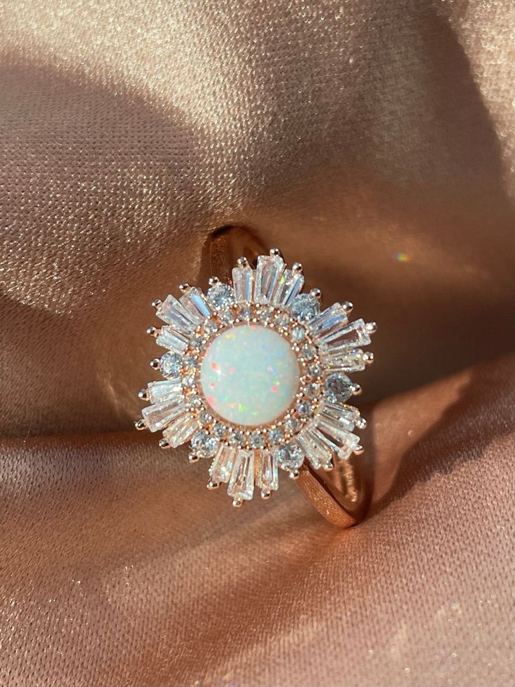 We couldn't find a showstopping opal statement ring for a reasonable price, so we decided to make our own and we absolutely did not hold back! 🤩 Our Supernova Ring is the opal ring of our dreams, bursting with a bright halo of explosive cubic zirconia baguettes around a mesmerizing, multidimensional simulated opal. The dazzling shine of our Supernova Ring is matched only by the astronomical burst of an exploding star. 🌟 * * * Don't know your ring size? View our Ring Size Guide * * * ………………………… Opal Statement Ring, Cute Engagement Rings, Future Engagement Rings, Dream Engagement Rings, Pretty Rings, Fantasy Jewelry, Opal Ring, Dream Jewelry, Pretty Jewellery