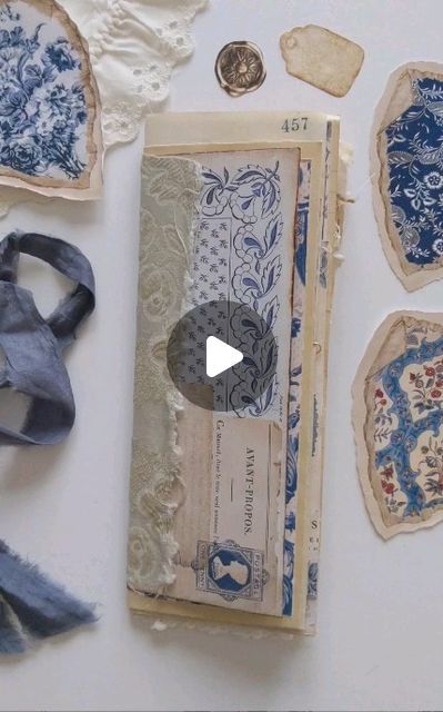 an old piece of paper with blue and white designs on it next to other pieces of fabric