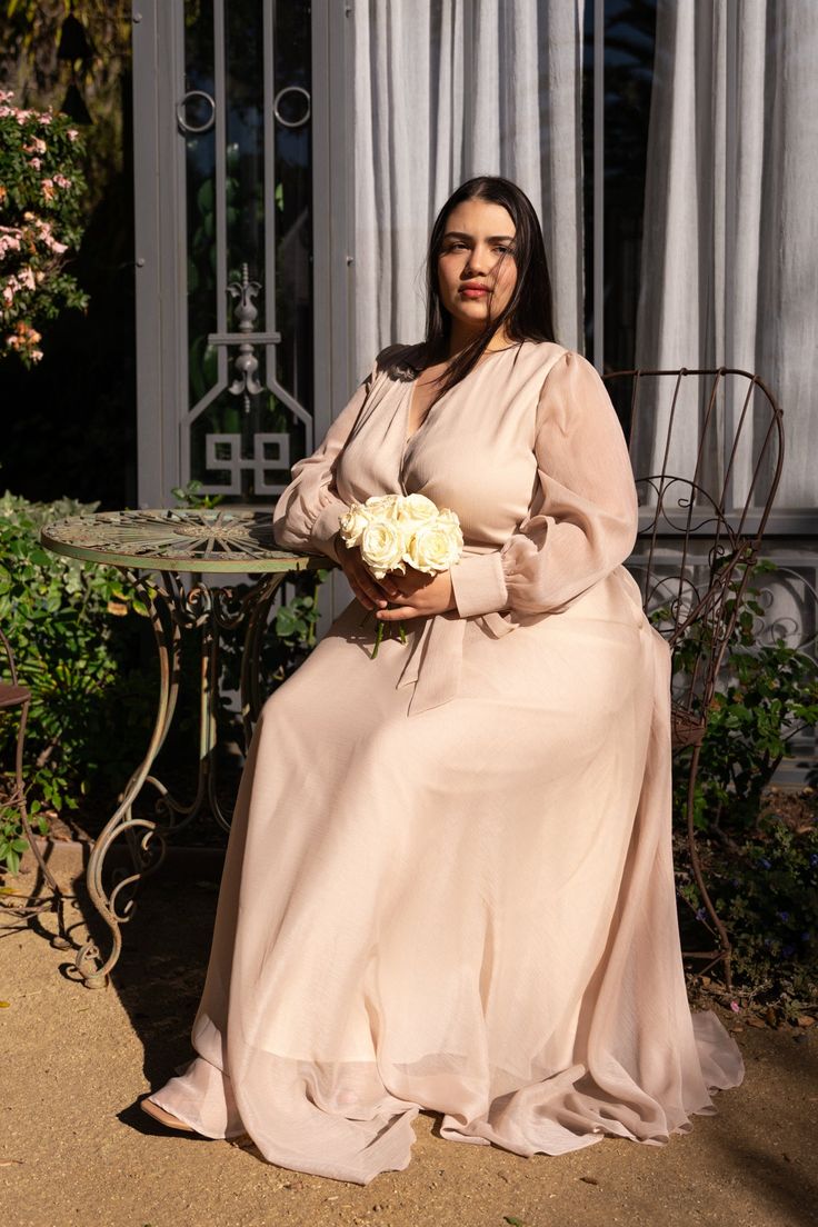 Introducing the Andie Dress in Champagne. Aka the perfect blend of style and comfort. This maxi dress features a soft champagne base with a flattering faux wrap bodice and elastic waist for a perfect fit. The functional pockets and lined bodice and skirt add practicality, while the fabric's stretch makes it suitable for both maternity and nursing. With a v neckline and long, unlined sleeves, this dress is versatile AND chic. Beige Ruched V-neck Maxi Dress, Chic Empire Waist Maxi Dress For Casual Occasions, Chic Empire Waist Maxi Dress For Casual Wear, Casual Chic Empire Waist Maxi Dress, Elegant Party Dresses With Elastic Waistband, Cream Maxi Length Dress With Flowy Skirt, Feminine V-neck Maxi Dress With Ruched Bodice, Cream Maxi Dress With Flowy Skirt, Chic Empire Waist Wedding Maxi Dress