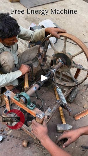 two men working on an old spinning wheel with the words free energy machine above them