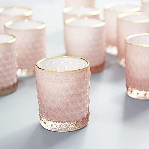 several pink glass cups with gold rims on a gray table top, all lined up and ready to be used