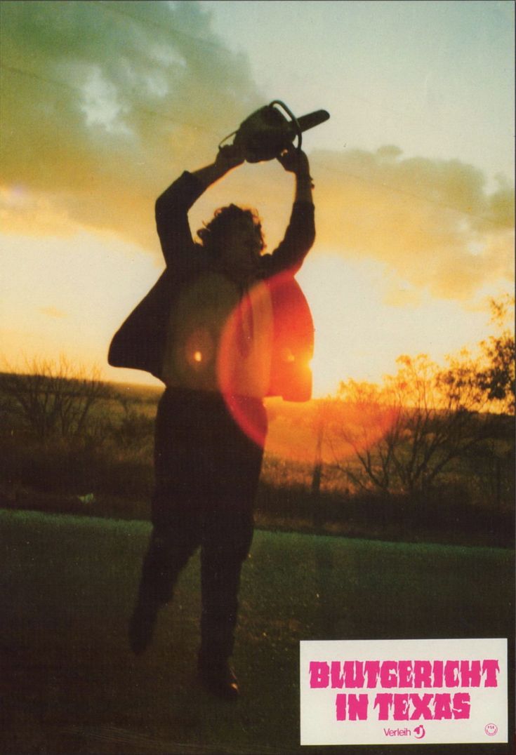 a man holding a skateboard over his head while standing on top of a field