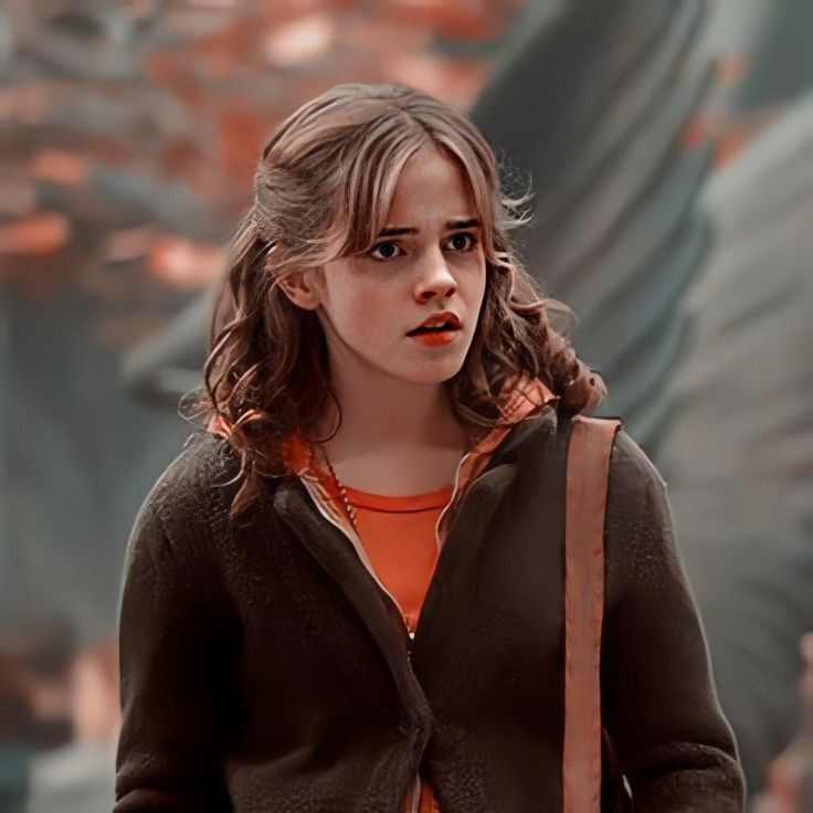 a young woman in an orange shirt and black jacket