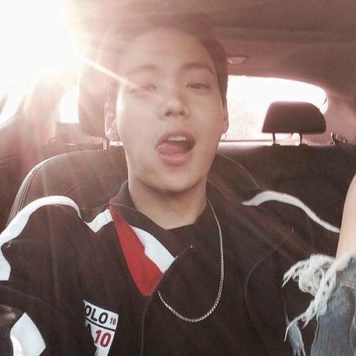 a young man sitting in the back seat of a car with his tongue hanging out