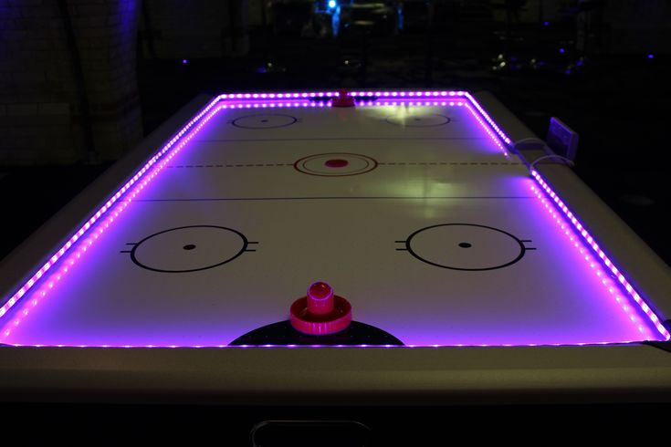 an ice hockey rink lit up with purple lights