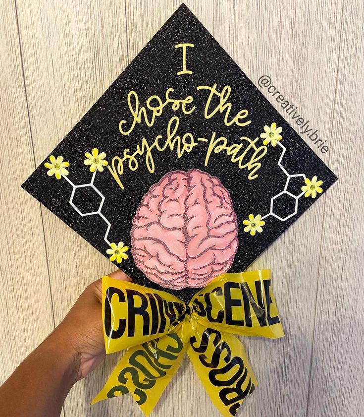 someone is holding up a graduation cap with a brain on it