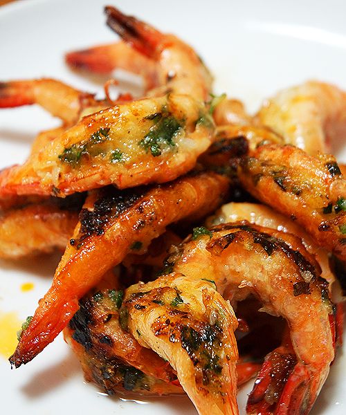 grilled shrimp on a white plate with lemon wedges