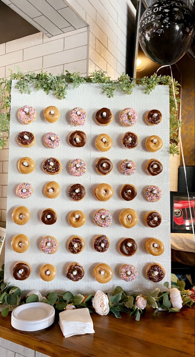 there are many doughnuts on the table and one is decorated with greenery