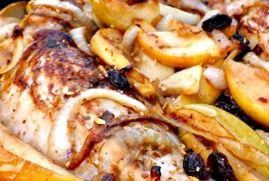 chicken, potatoes and olives in a pan with sauce on top for garnish