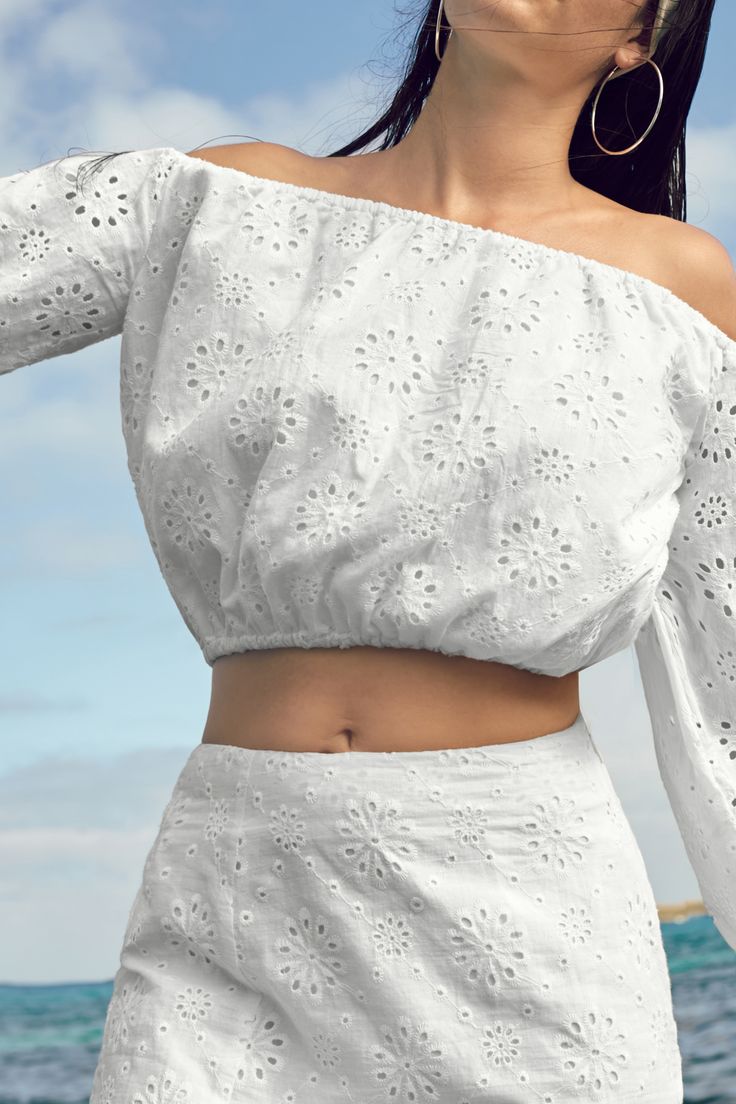 Embrace boho vibes with our Floral Eyelet Off-Shoulder Top. The charming floral eyelets and off-shoulder design make it perfect for breezy, carefree days. Product code: CAA04B4E060CC Features:  Woven Off-shoulder styling Long peasant sleeves Bubble hem Elasticized trim Material: 100%COTTON. White Off-shoulder Summer Top For Vacation, Spring Off-shoulder Top For Day Out, Bohemian Summer Eyelet Tops, Bohemian Eyelet Tops For Summer, Summer Cold Shoulder Off-shoulder Top For Day Out, Bohemian Eyelet Top For Spring, Spring Bohemian Eyelet Top, Bohemian Off-shoulder Top For Beach, White Off-shoulder Top For Summer Vacation