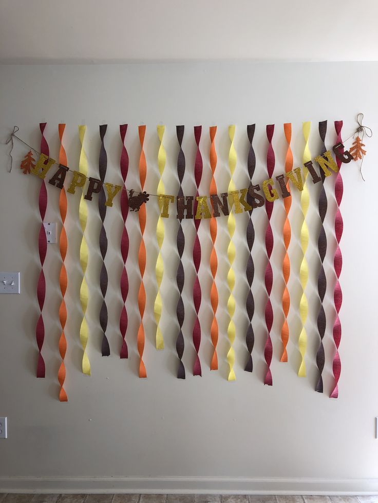 a birthday banner made out of paper streamers on a wall in a room with wood flooring