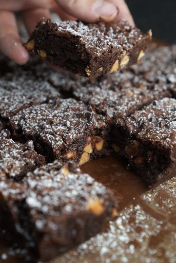 a person is picking up some brownies from a tray