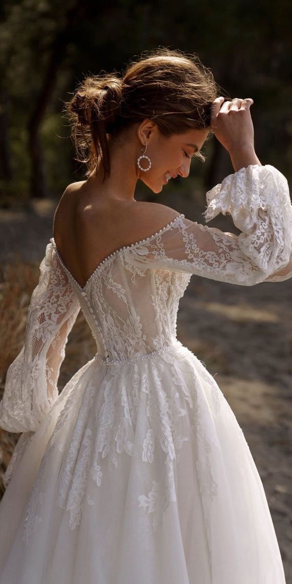 a woman in a wedding dress is posing for the camera with her hand on her head