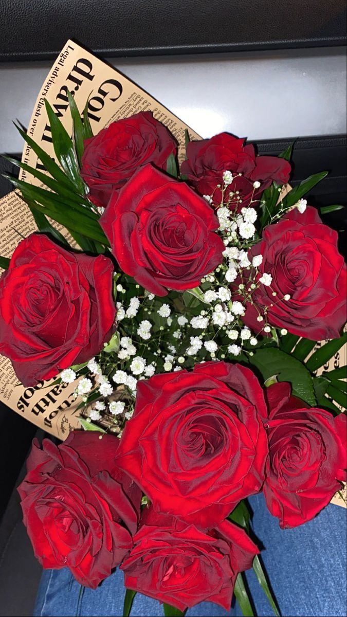 a bouquet of red roses sitting on top of a table